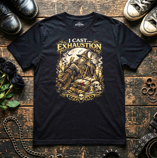 Black t-shirt with 'I Cast Exhaustion' graphic design on a wooden surface with shoes and decorative items.