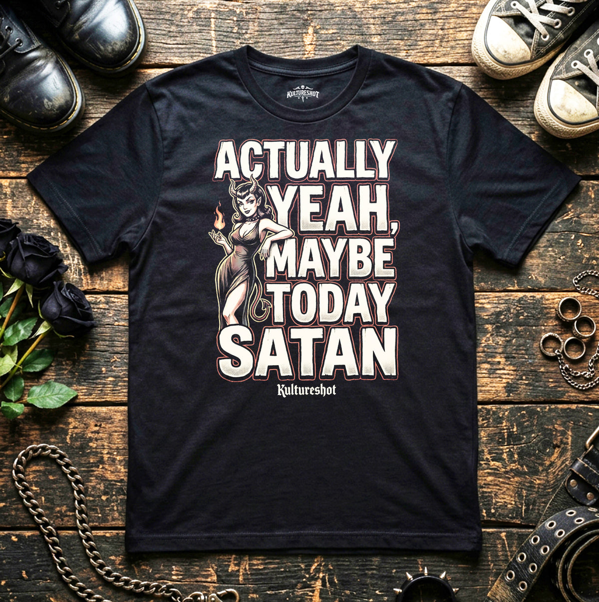 Black t-shirt with graphic design and text on a wooden surface with shoes and roses.