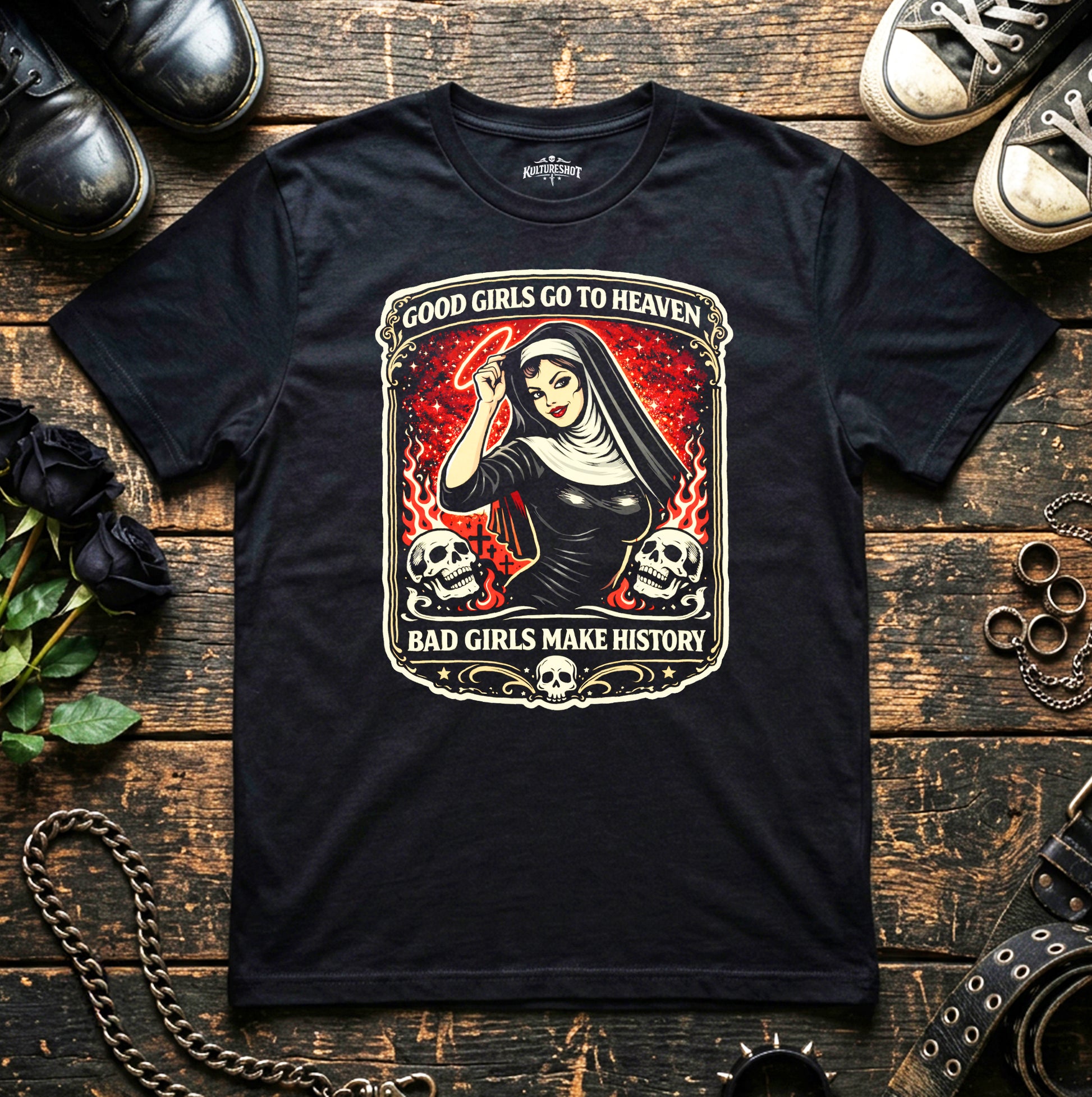 Black t-shirt with a graphic design featuring a nun and text on a wooden surface with shoes and roses.