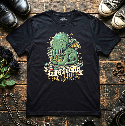 Black t-shirt with a green Cthulhu design and 'Eldritch But Chill' text on a wooden surface.