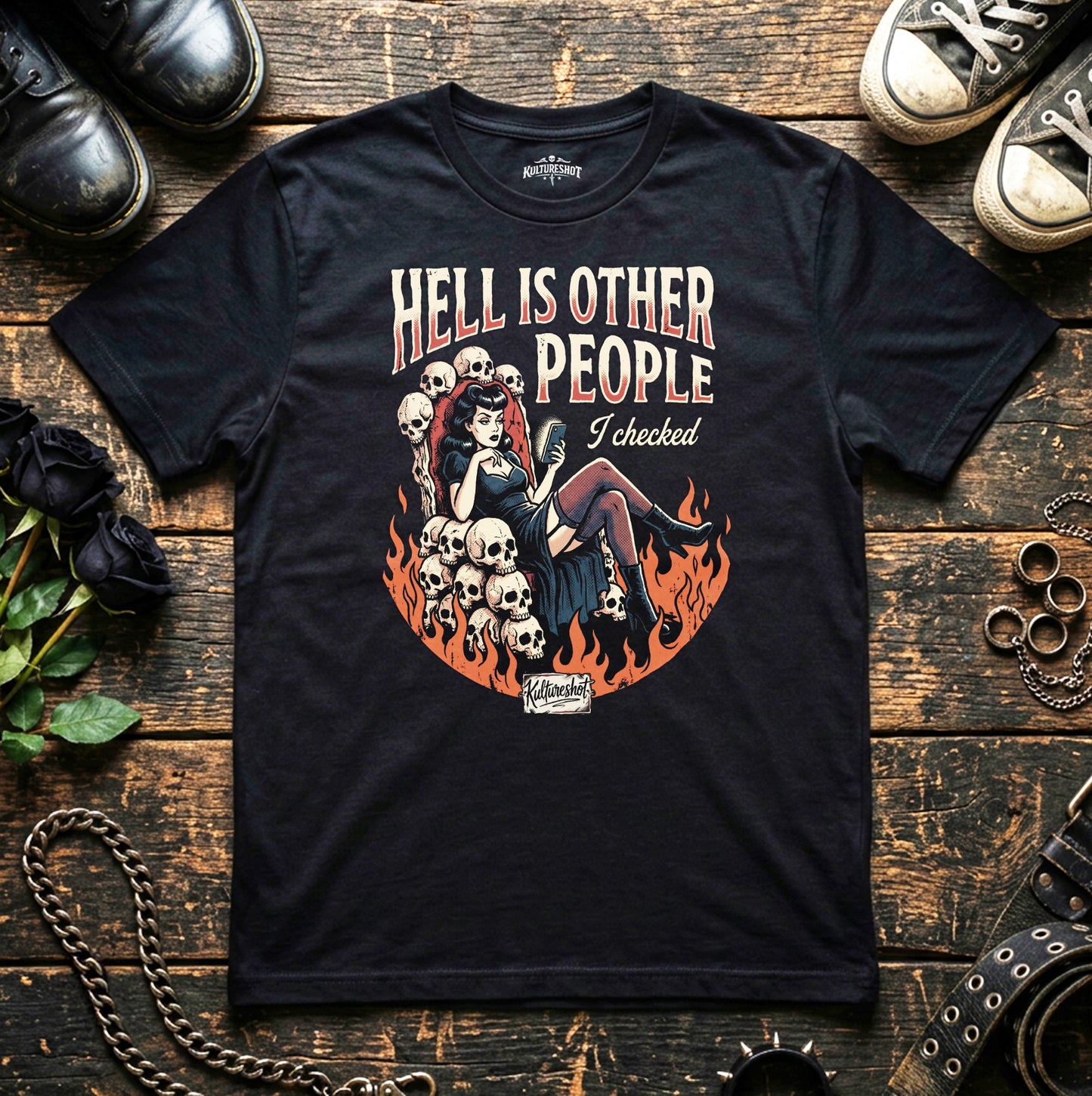 Black t-shirt with graphic design and text on a wooden surface with shoes and roses.