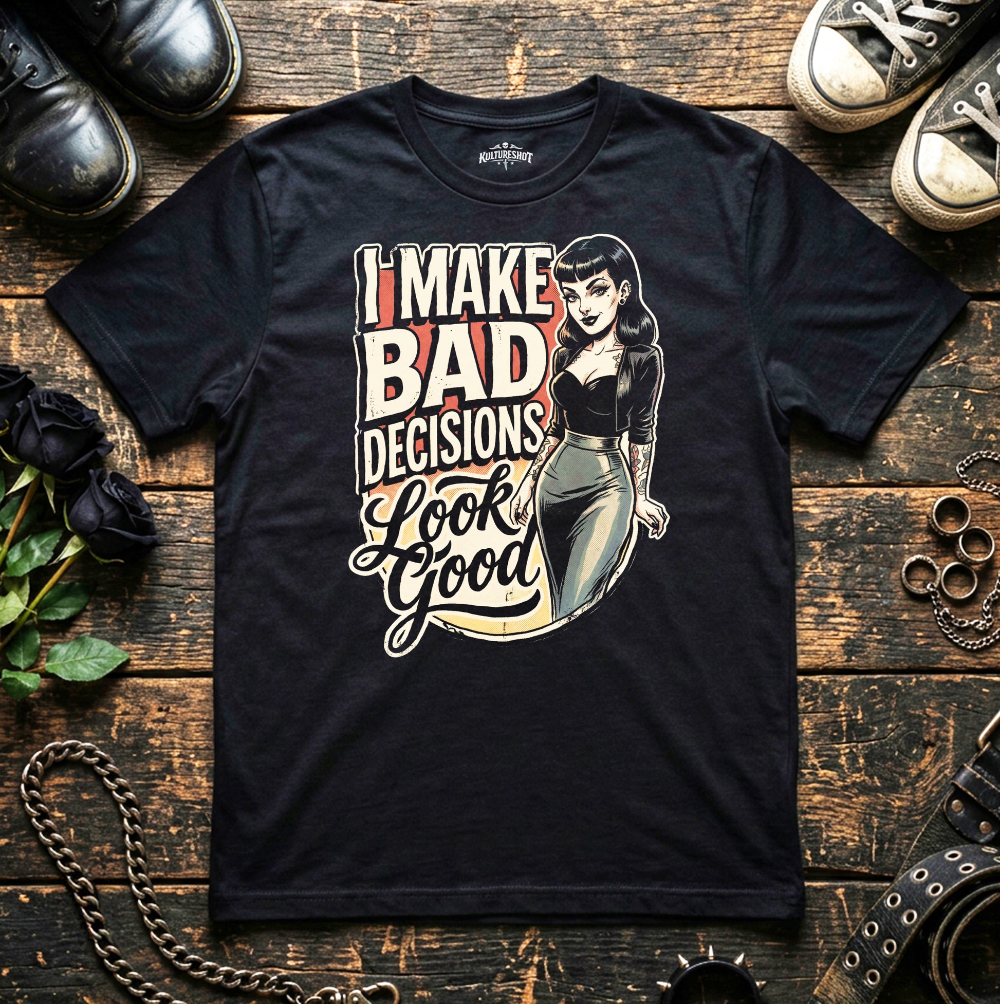 Black t-shirt with graphic design and text on a wooden surface with shoes and chains.