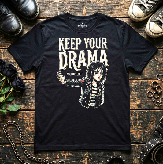 Black t-shirt with graphic design and text on a wooden surface with shoes and accessories.