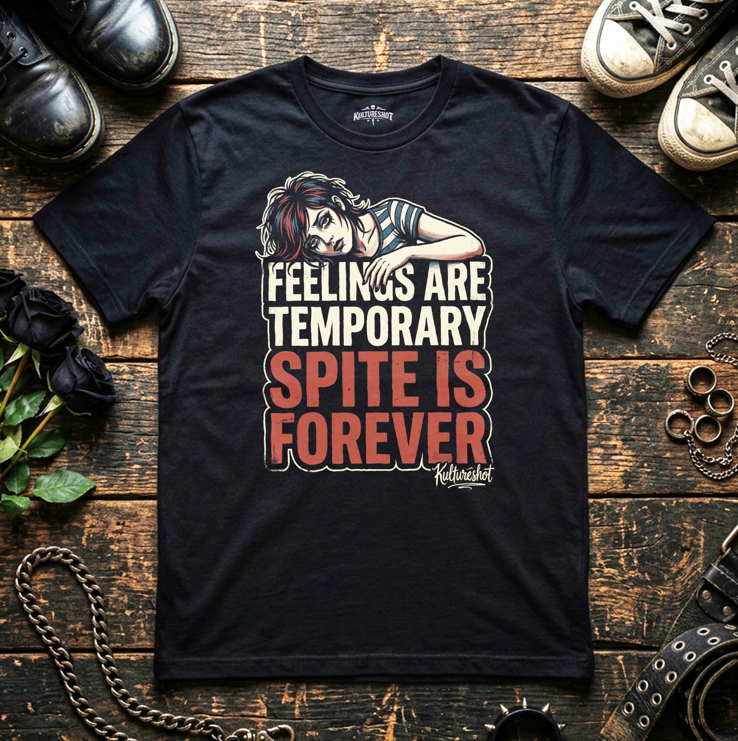 Black t-shirt with a graphic and text on a wooden surface with shoes and flowers.