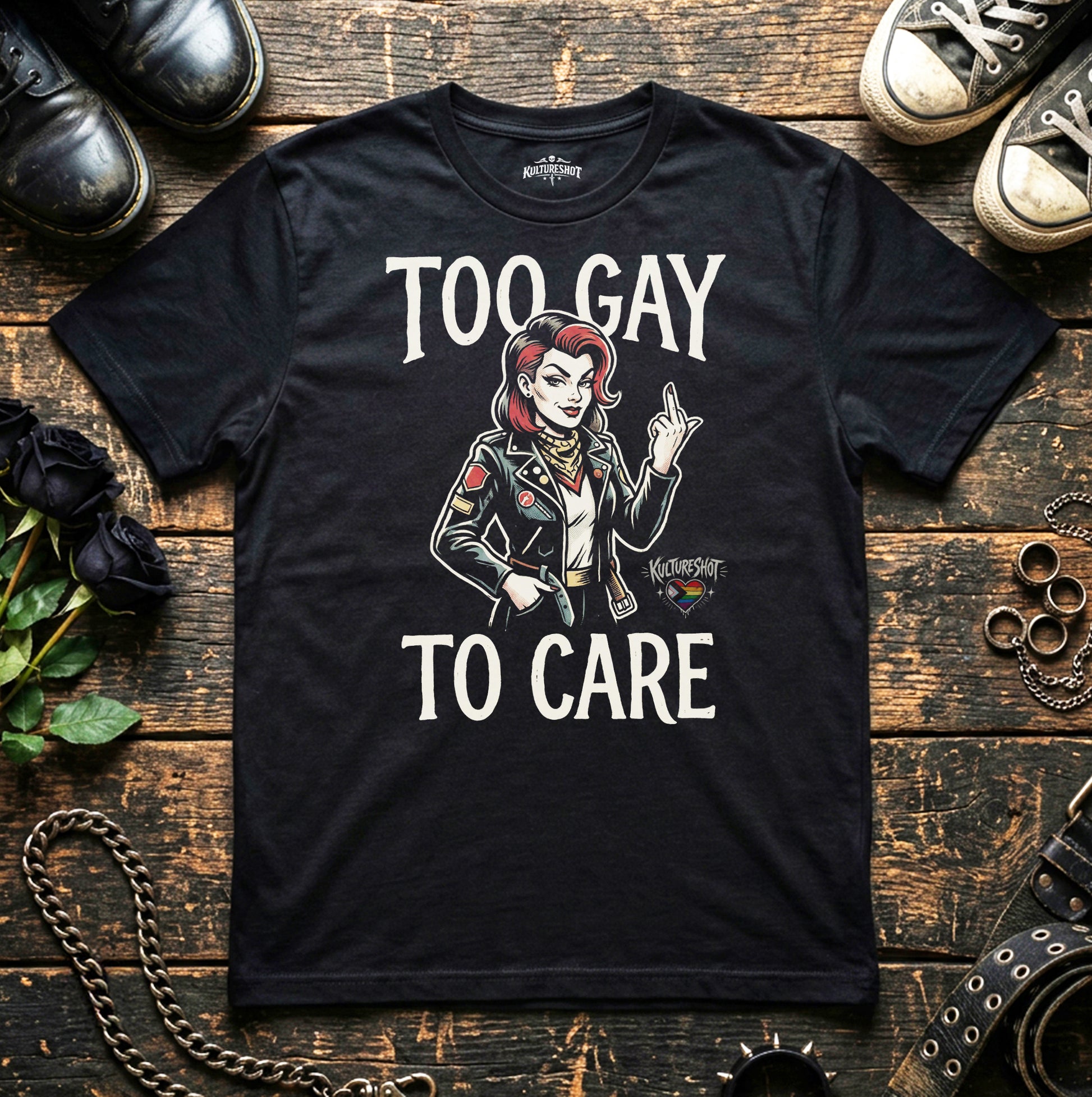 Black t-shirt with graphic design and text on a wooden surface with shoes and accessories.