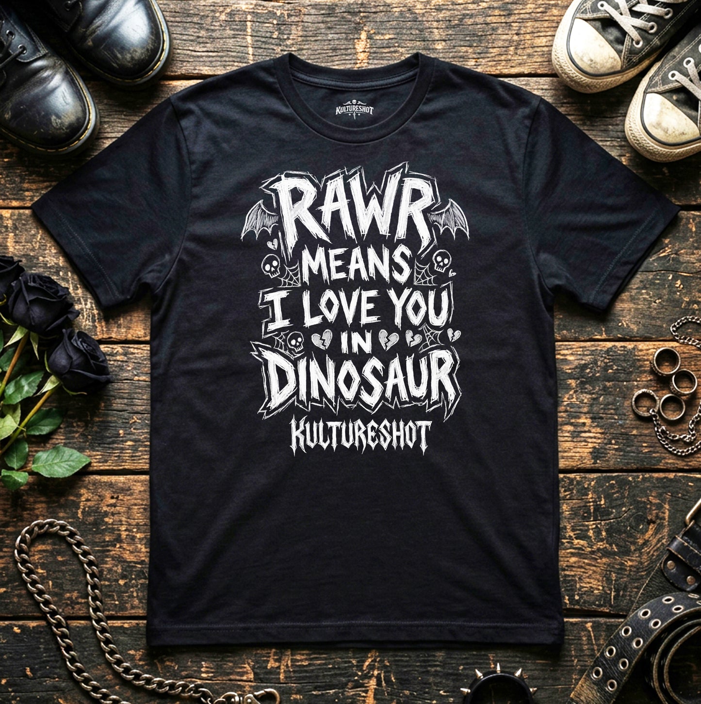Black t-shirt with white graphic text on a wooden surface with shoes and chains.
