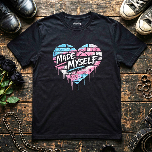 Black t-shirt with a colorful heart design and text on a wooden surface with shoes and accessories.