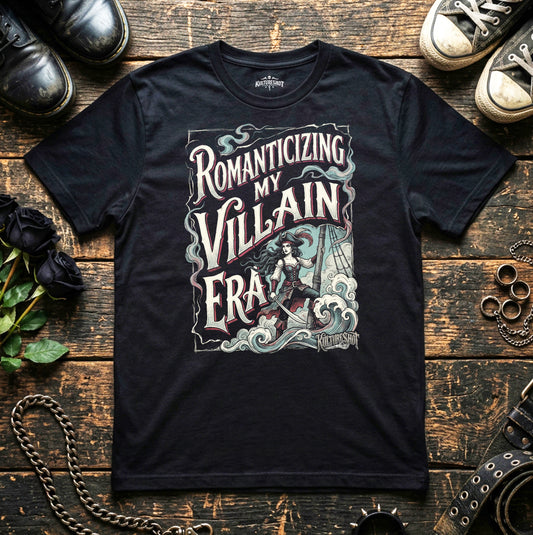 Black t-shirt with graphic design and text on a wooden surface with shoes and roses.