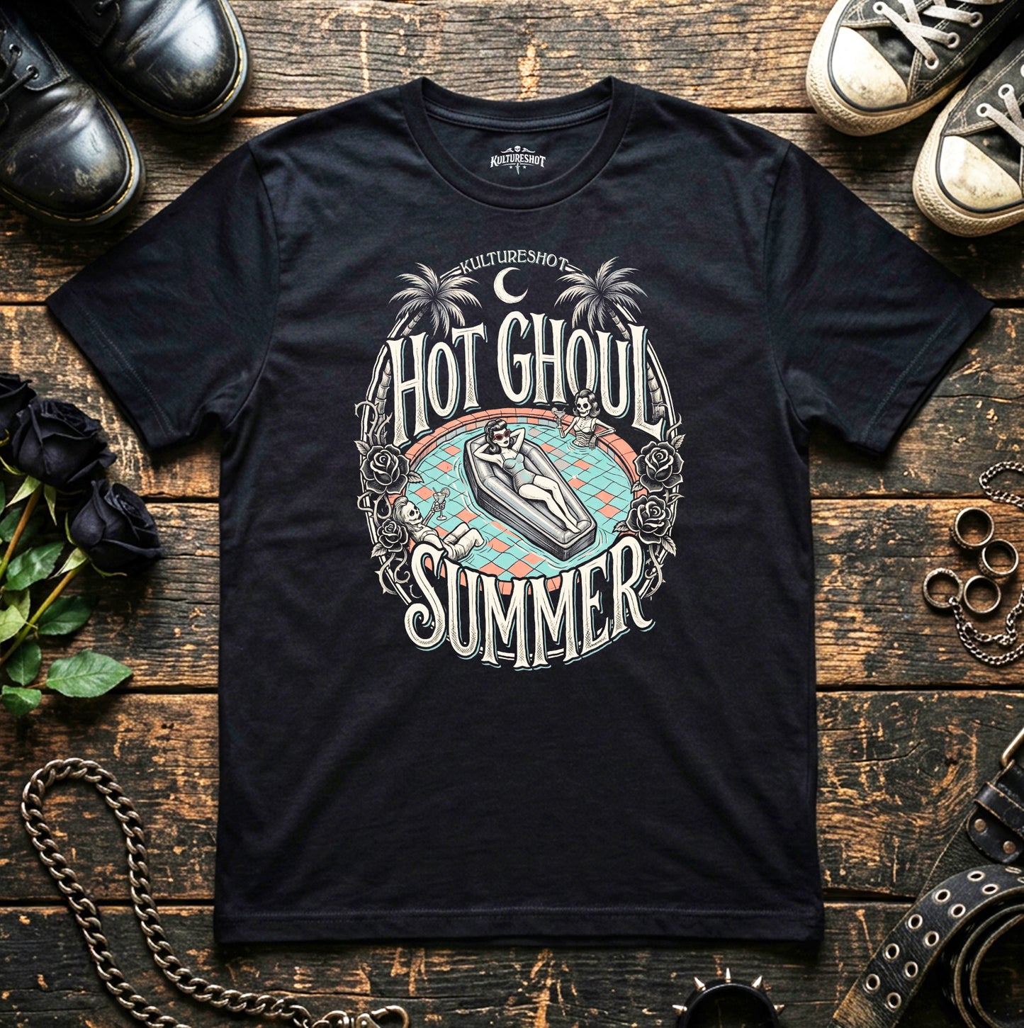 Black t-shirt with 'Hot Ghoul Summer' graphic design on a wooden surface with shoes and plants.