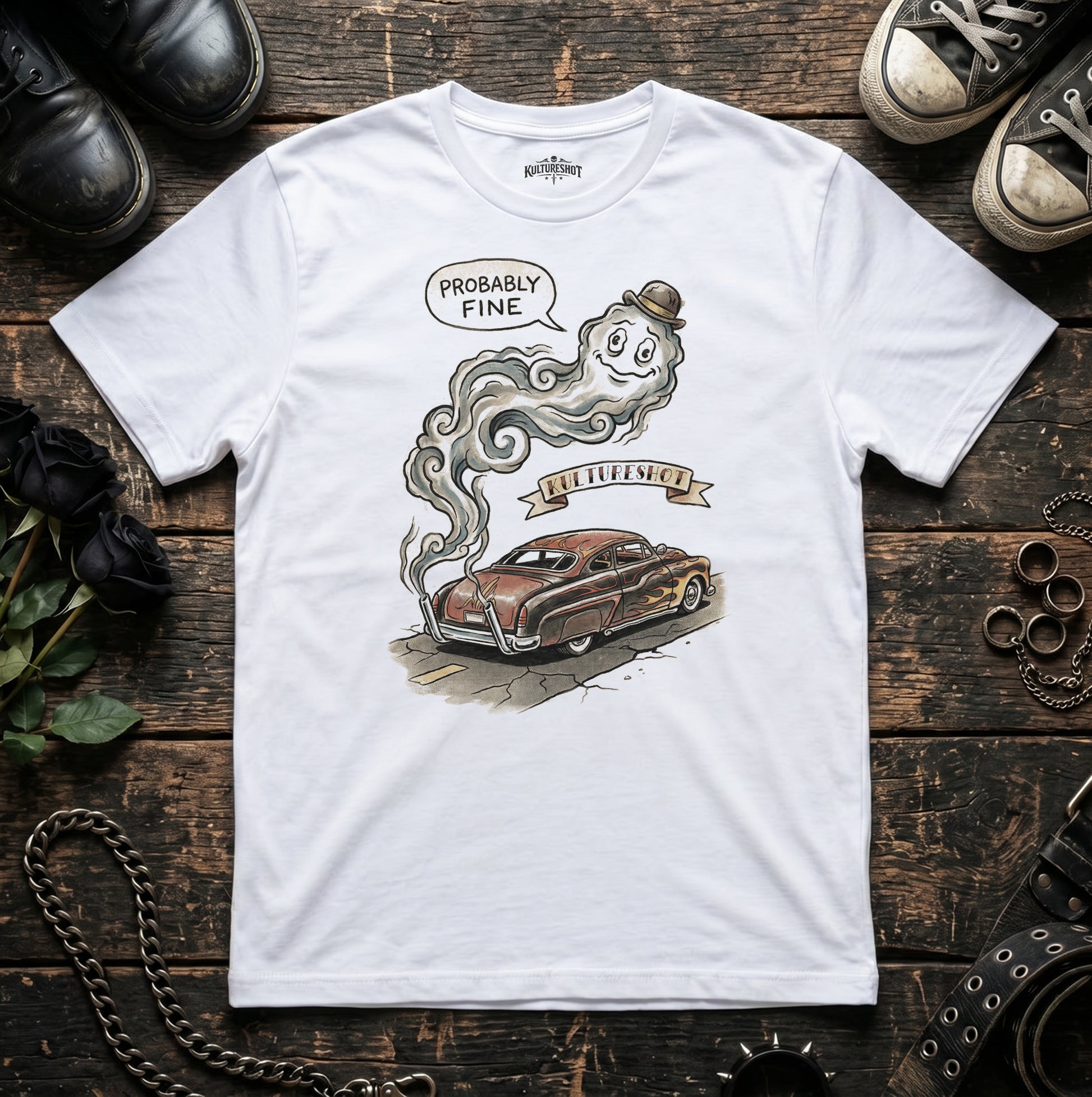 White t-shirt with a graphic design of a car and ghost on a wooden surface.