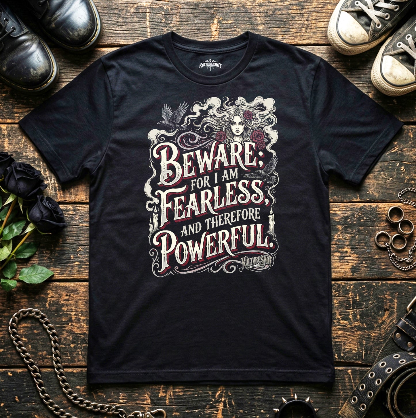 Black t-shirt with a motivational quote on a wooden surface with shoes and accessories.