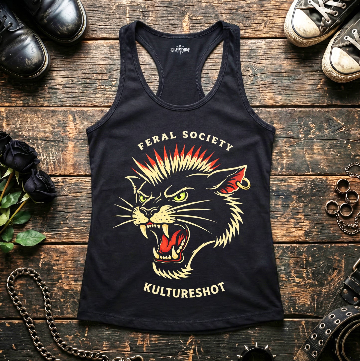Black tank top with a graphic design of a roaring cat and text on a wooden surface with shoes and accessories.