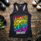 Black tank top with colorful text on a wooden surface with shoes and accessories.