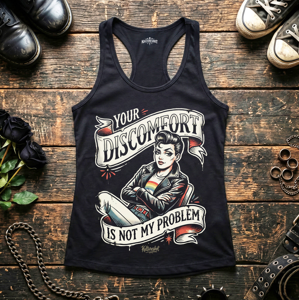 Black tank top with graphic design on a wooden surface with shoes and accessories.