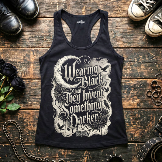 Black tank top with white text and graphics on a wooden surface with shoes and roses.