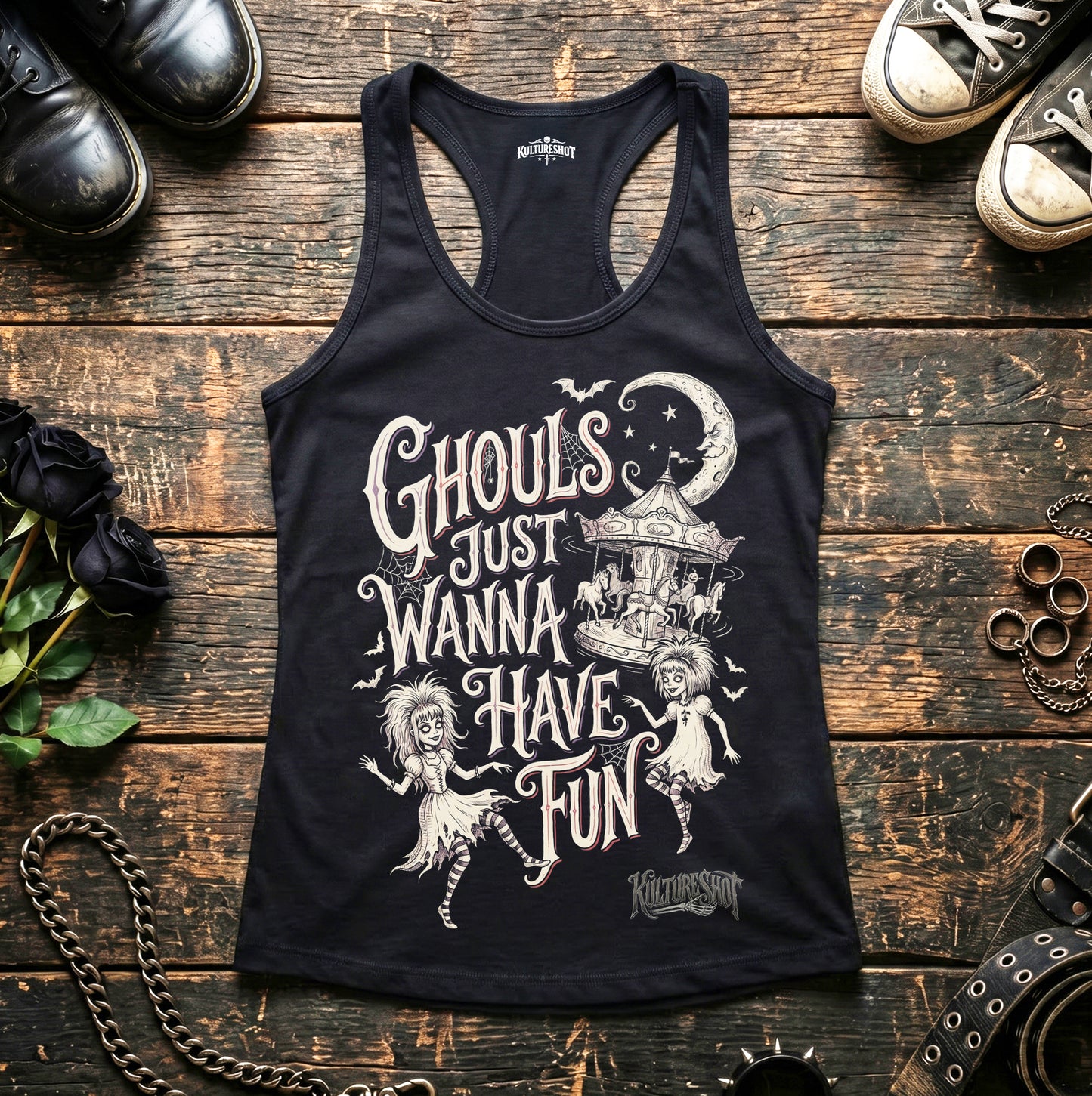 Black tank top with ghoul design on a wooden surface with shoes and decorative items.