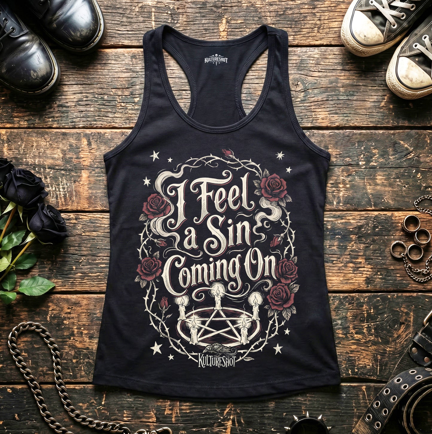 Black tank top with graphic design and text on a wooden surface with shoes and roses.