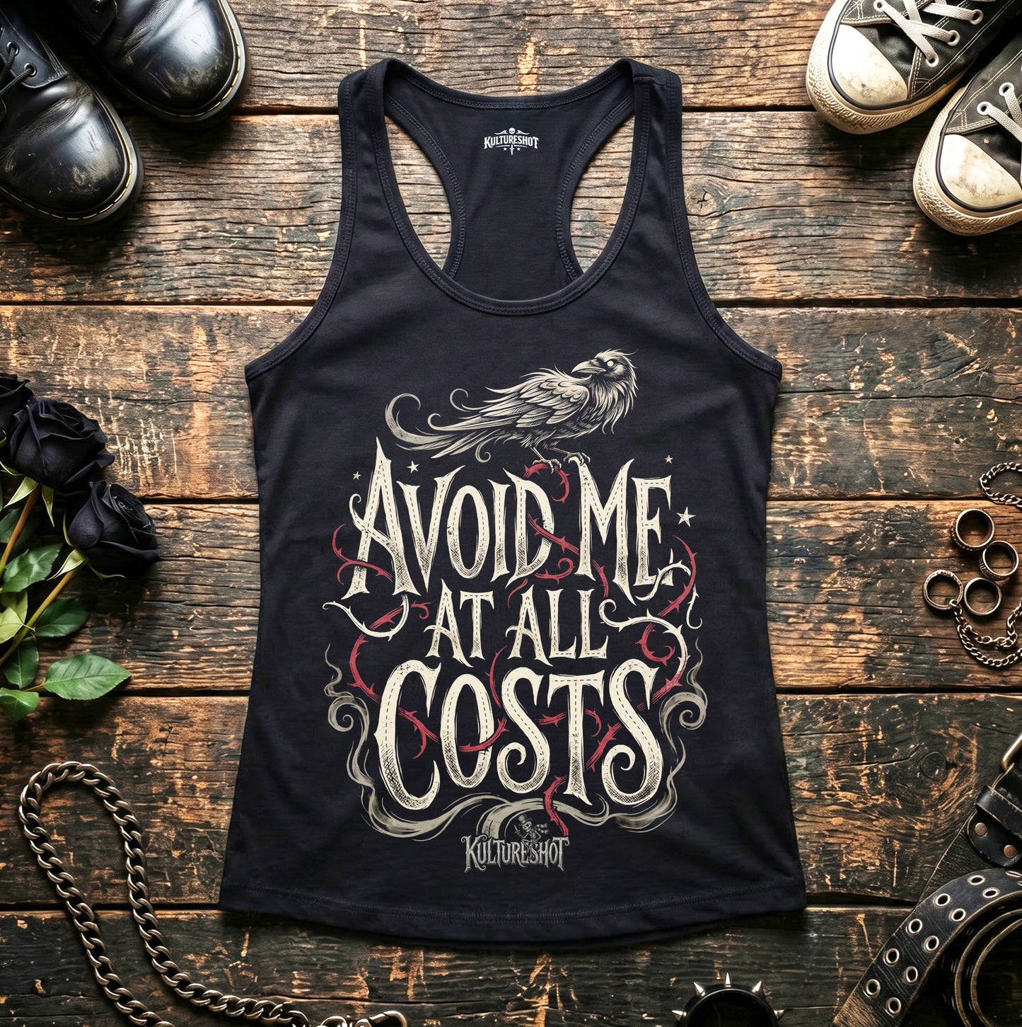 Black tank top with text design on a wooden surface with shoes and accessories.
