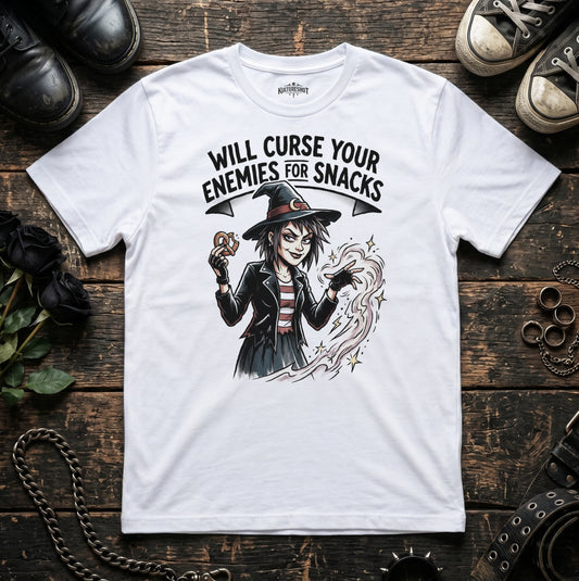 White t-shirt with a witch graphic and text on a wooden surface with shoes and jewelry.