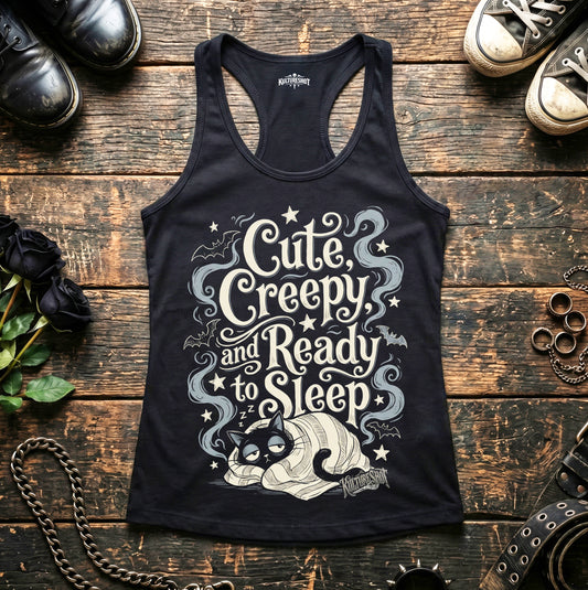 Black tank top with cat graphic and text on a wooden surface with shoes and roses.
