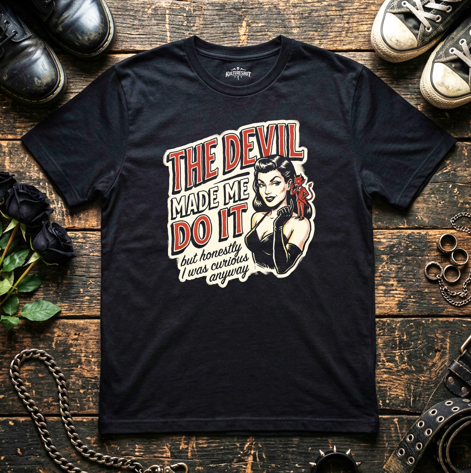 Black t-shirt with graphic design and text on a wooden surface with shoes and roses.
