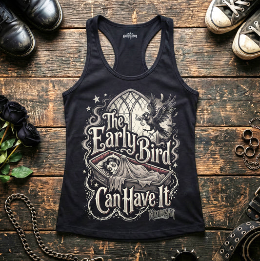 Black tank top with graphic design on a wooden surface with shoes and decorative items.